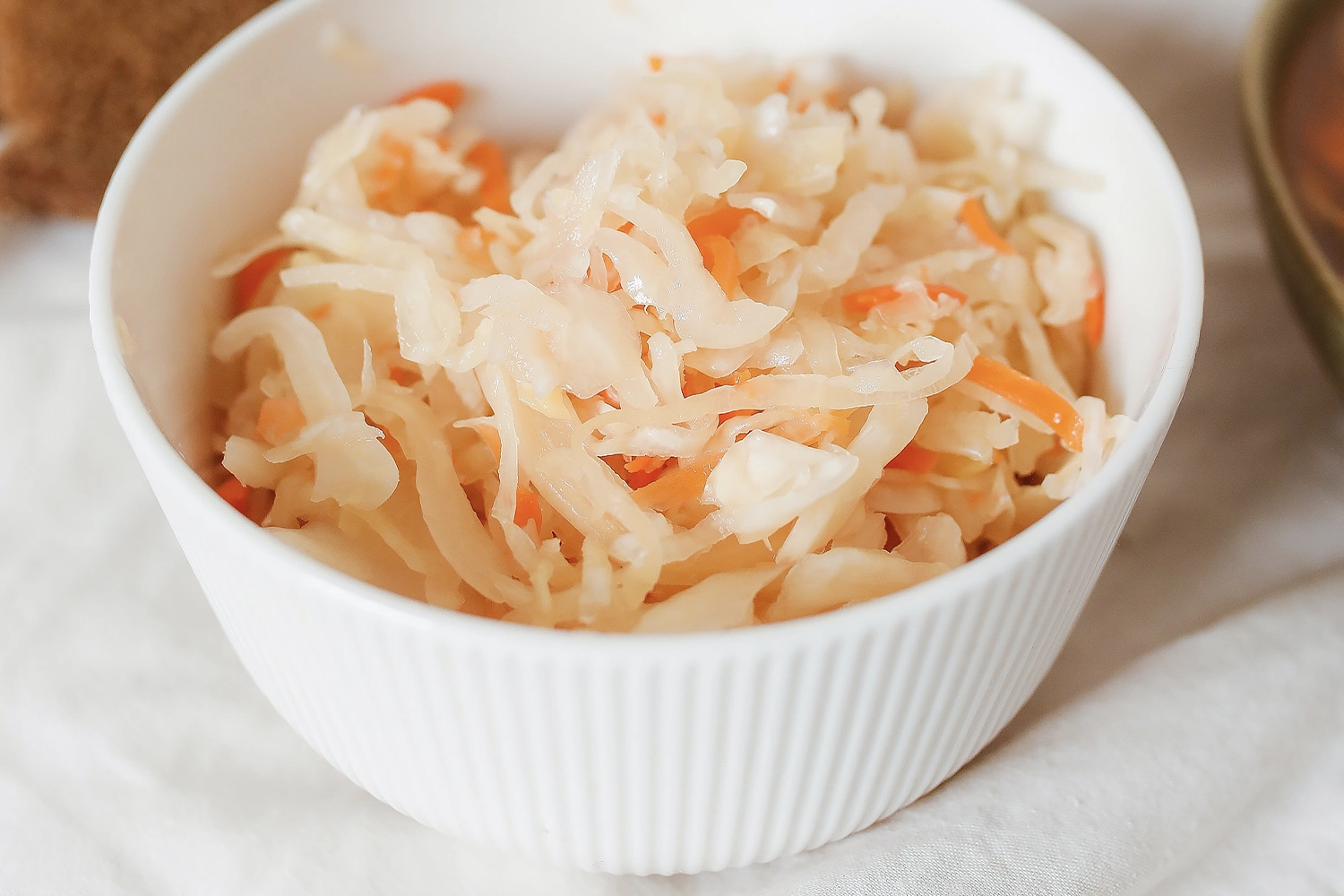 white bowl of pickled carrots, cabbage and radish